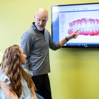 Orthodontist showing patient a scan of her teeth